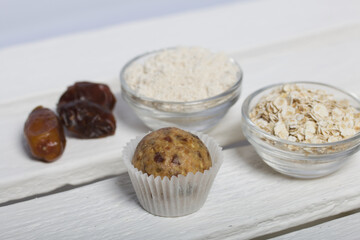 Dried fruit and oatmeal sweets. Nearby ingredients for their preparation. On a white wooden box.