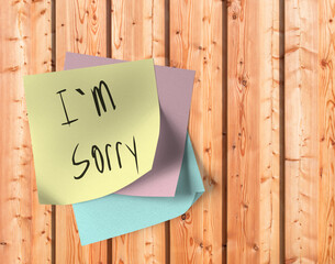 Klebezettel mit der Aufschrift I´m sorry, an einer Holzwand