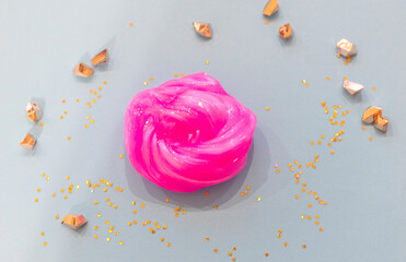 close up hand made toy called slime. pink slime on blue background