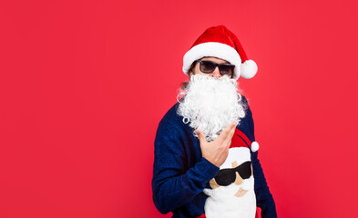 present and gift shopping sale. happy new year. merry christmas. cheerful bearded man in santa claus hat and sweater. brutal hipster celebrate xmas party. winter holiday preparations. copy space