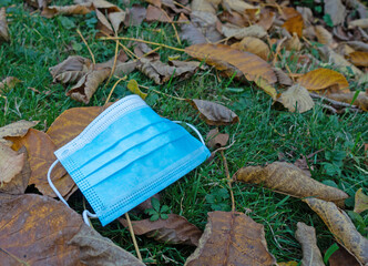 Mundschutzmaske im Herbstlaub auf der Wiese