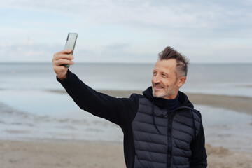 Fit active man taking a selfie at the beach
