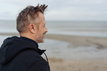 Man taking a walk on a windy cold beach