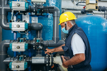 industrial worker inspecting chemical treatment equipment