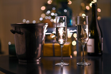 two glass with champagne on table and bengal fire background. Happy new year concept 