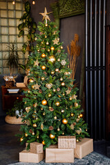 Golden star on the Christmas tree, Christmas tree decoration with Golden balls garland, green spruce in the interior of the apartment, preparation for the Christmas holiday