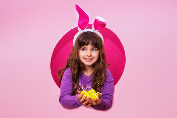 Obraz na płótnie Canvas Cute little girl with Easter bunny ears holding 