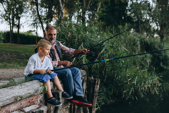 boy fishing on the lake with his grandfather