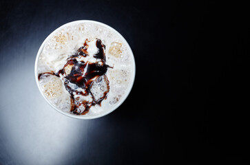 
Tasty coffee drink with milk and chocolate on wooden table in cafe. Milkshake in disposable paper cup, top view