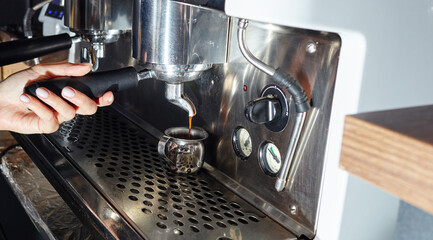 Barista preparing coffee drink with espresso machine in coffee shop cafe. Blurred image, selective focus
