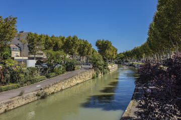 Fototapeta na wymiar Canal de la Robine passes through the city of Narbonne; it connects the Aude and the Mediterranean Sea in the Aude department. Narbonne, Languedoc-Roussillon, France.