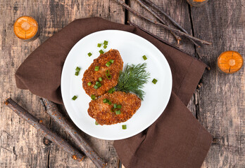 Turkey cutlets with herbs on a wooden background. The view from the top. Concept of culinary backgrounds.