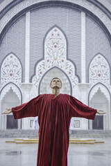 Naklejka premium Inspired man in red looking up to the sky with arms outstretched sides