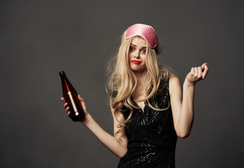 Beautiful blonde with a bottle of beer in her hand and a pink mask on her head