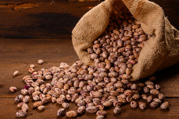 Colored beans on wooden background.