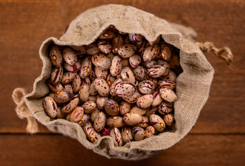 Colored beans on wooden background.