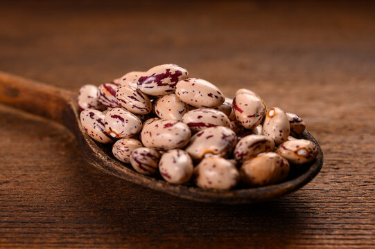 Colored beans on wooden background.