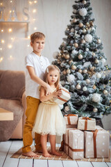 children in the new year's interior at the Christmas tree, playing, waiting for the new year, gifts, holiday, happiness