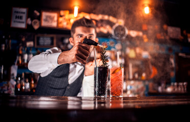 Young tapster makes a cocktail in cocktail bars