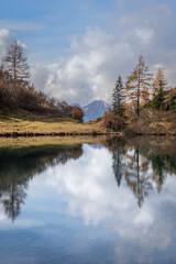 Fototapeta na wymiar Symmetrical reflections in Lake Spigorel in autumnal guise - Orobie - Italian Alps