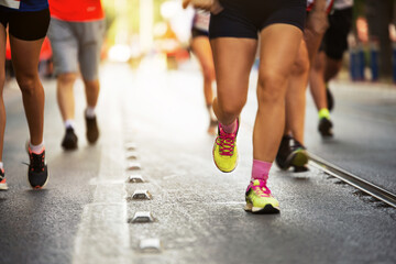 Close up shot of Marathon runners legs on an asphalt road.