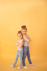 Image Of Two Happy Sisters Having Fun on yellow background