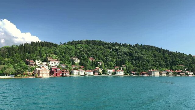 Footage of historical mansions at upscale neighborhood called "Kandilli" in Istanbul. It is a beautiful Bosphorus scene in a sunny summer day. Camera moves forward.