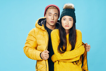 man of Asian appearance hugs a woman in a yellow jacket