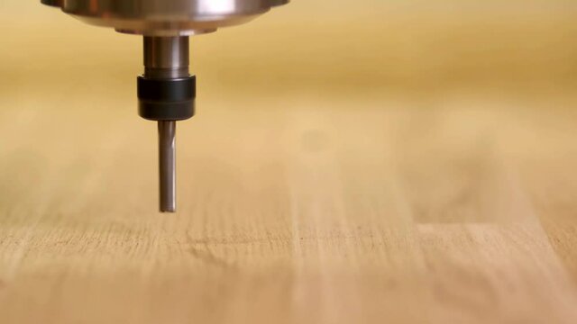 CNC wood starts, lowers the drill and begins to cut the wooden part, according to the route. Head. Close up