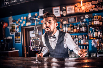 Professional barman creates a cocktail behind the bar