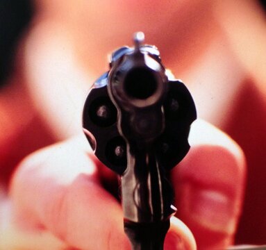 Close-up Of Blurred Hand Holding Gun