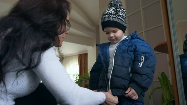 Mother Zipping her Sons Warm Waterproof Children Jacket. Little Child Boy Wearing Winter Attire. 2x Slow motion 60 fps 4K