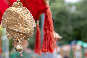 Decorations with bells and coins on red decorative paper umbrella, traditional symbol of indonesian...