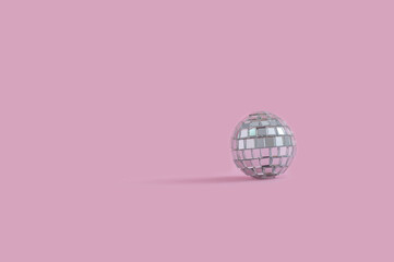 Disco ball on pastel pink background as concept for Christmas and holiday season.