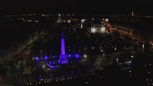 Monument of freedom at night in Riga, Latvia during Staro Riga event. Milda - Statue of liberty holding three stars over the city illuminated in different colors. 
