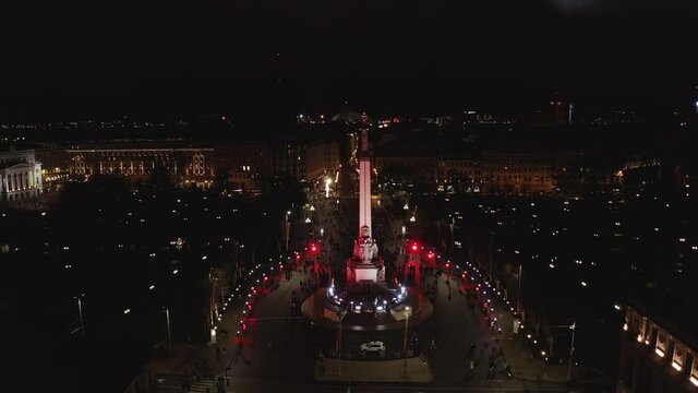 Monument of freedom at night in Riga, Latvia during Staro Riga event. Milda - Statue of liberty holding three stars over the city illuminated in different colors. 