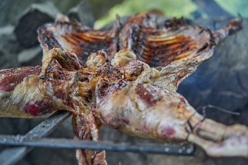 rustic lamb barbecue bbq over open fire in Patagonia, Argentina, South America. Asado is a Gaucho traditon with cooking on open flame
