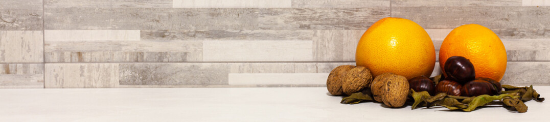 Banner background with orange, tangerine, grapefruit, walnuts and chestnuts on leaves autumnal...