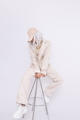 Urban Girl in studio. Trendy beige casual look. Denim Suit Jacket and Pants. Style in details. Fall winter season. White aesthetic