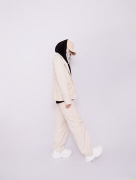 Blonde Girl in white studio. Trendy beige casual outfit with black hoodie details.  Cap, Denim Suit Jacket and Pants. Street Style. Fall winter season.  Fashion lookbook concept