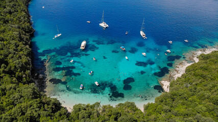Aerial drone photo of iconic sandy beach and floating boats in Sivota, Epirus, Greece