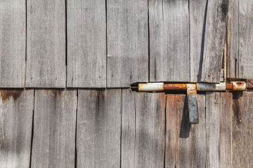 Rusty door bolt in old unpainted doors