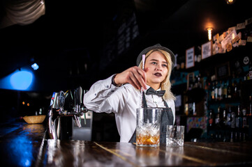 Girl barman creates a cocktail in the porterhouse