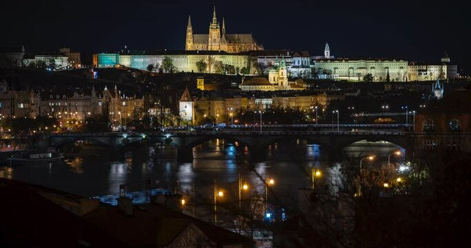 
illuminated Charles Bridge from 14 centuries and light from street lighting and stone sculptures on the bridge and light reflections on the surface of the Vltava river at night in Prague