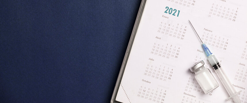 syringe and vaccine with calendar 2021, blue background