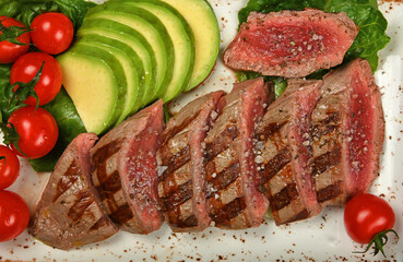 Grilled beef steak sliced and served with salad