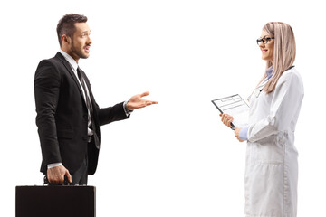 Young man with a briefcase talking to a young female doctor