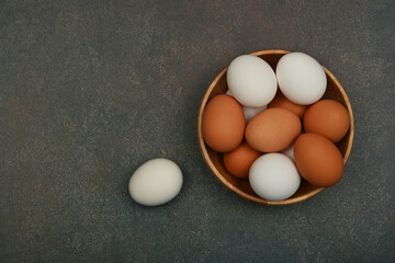 Bowl of brown and white chicken eggs on table