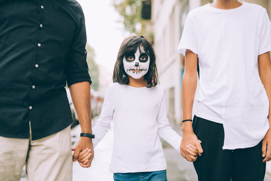 Girl with Halloween face paint, holding hands