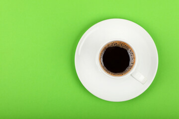 Full white espresso coffee cup over green